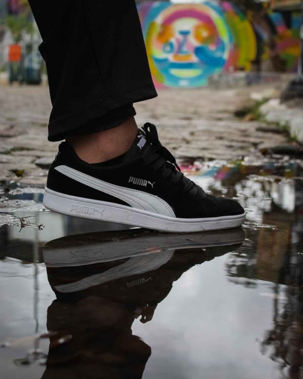 a person in white and black puma suede shoe